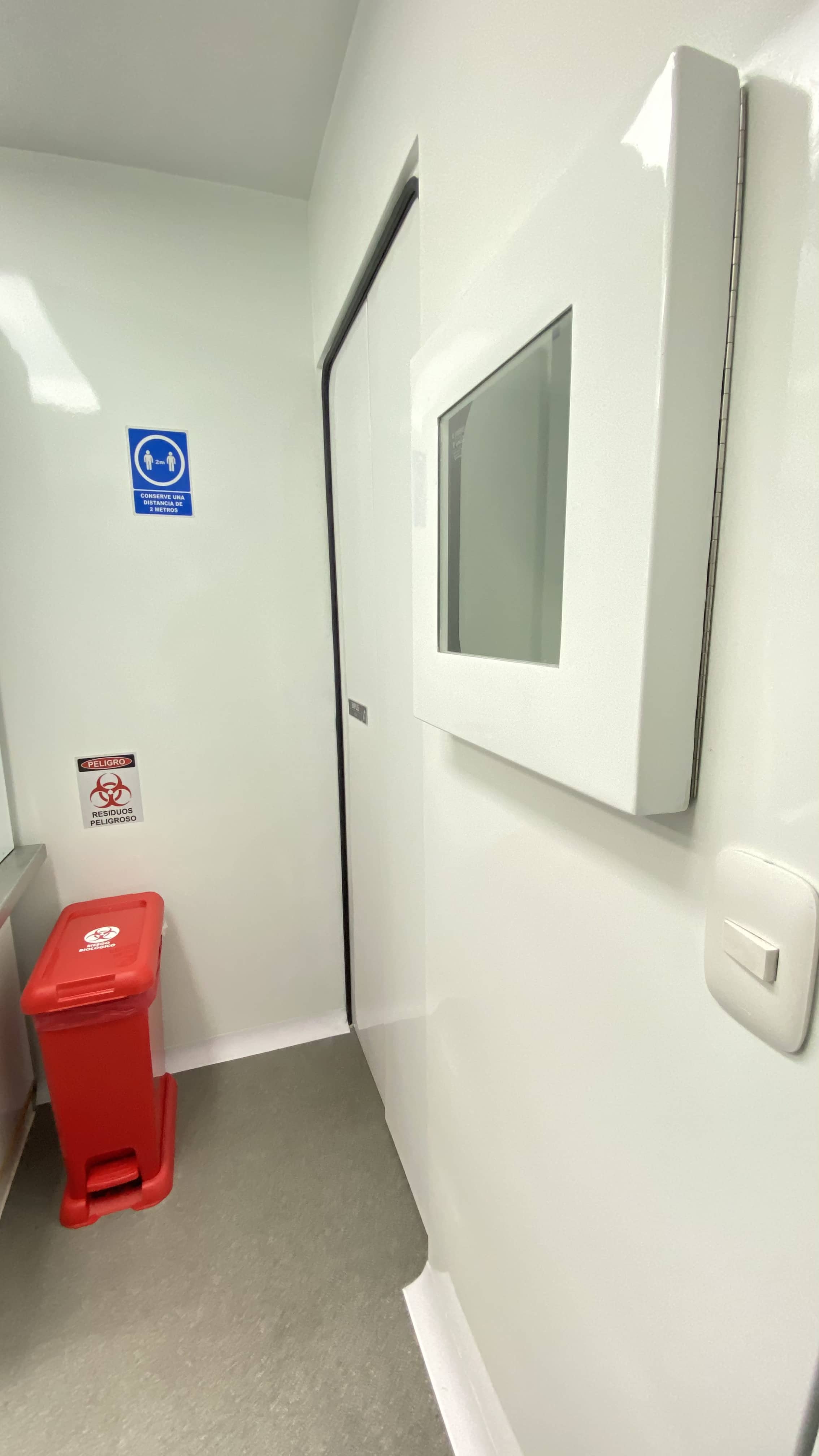Biosafe zone detail: the combination of biological hazard signage, hazardous waste container, and sample transfer window defines the rigor of a Class 2 molecular diagnostic laboratory.